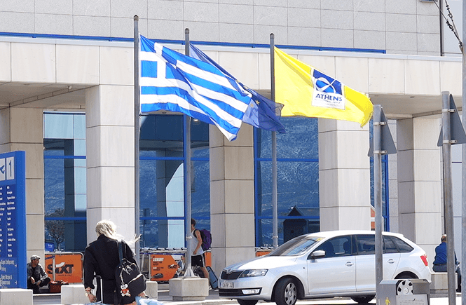 Photo of the Greek flag outside of Athens International Airport.